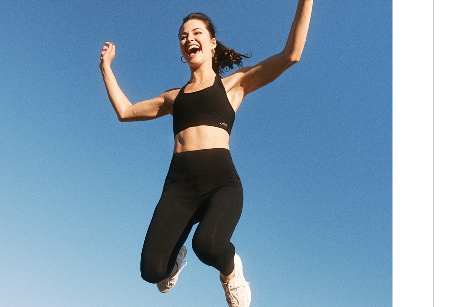 Decorative image of woman jumping in black Lorna Jane sports bra and leggings